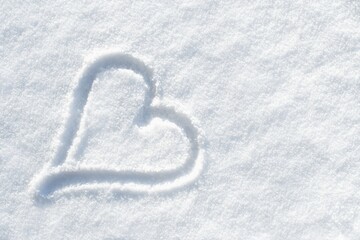 Heart in the white fresh snow. Winter or Valentine background.