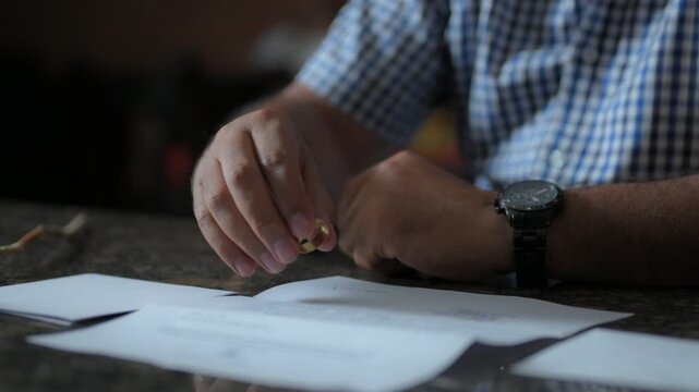 Hombre triste quit&aacute;ndose el anillo de matrimonio frente a papeles legales de separaci&oacute;n