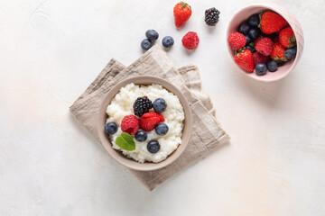 Rice milk porridge in with berries in a bowl on the table. Healthy breakfast. Top view