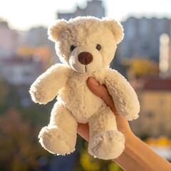 A cute teddy bear holding a red rose and a small toy sits against a clean white background