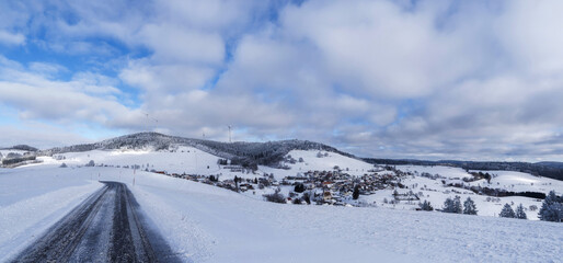 Verschneite Landschaft des Schwarzwaldes. Blick vom Gersbach-M&ouml;hrenblick auf den Ortskern am Fu&szlig;e des Rohrenkopfes mit seinen Windkraftanlagen und dem bewaldeten Gipfel des Bergkopfes
