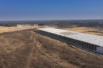 Rozległy płaski teren, nieużytki rolne porośnięte chwastami. Budowa dw&oacute;ch hal produkcyjnych w strefie ekonomicznej.  