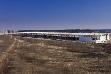 Rozległy płaski teren, nieużytki rolne porośnięte chwastami. Budowa dw&oacute;ch hal produkcyjnych w strefie ekonomicznej.  