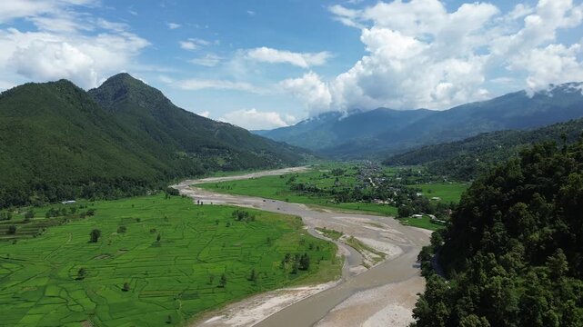 Aerial Drone View of Nuwakot Valley with River Dividing Paddy Fields and Surrounding Mountains