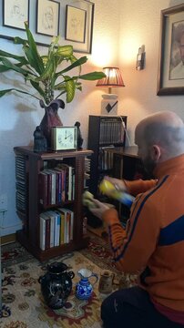 Hombre pasando el polvo y limpiando en casa