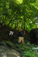 Fototapeta premium Plus-size man taking smartphone selfie while hiking in lush green forest