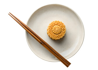 Traditional Chinese mooncake on ceramic plate with wooden chopsticks for Mid-Autumn Festival