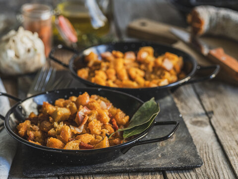 Close-up of two plates of migas, traditional Spanish food, served on a rustic table
