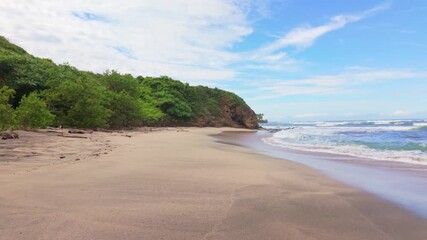 Scenic view of sandy beach and green cliff at Playa Blanca Guanacaste