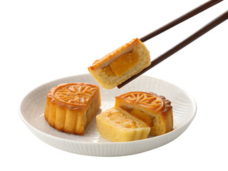 Traditional mooncakes on white plate being picked with chopsticks