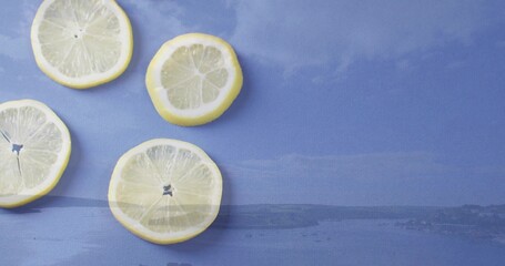 Displaying four lemon slices clustered on left of blue cloth with coastal horizon print, copy space