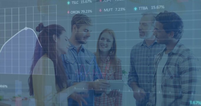 Reviewing group of five in casual shirts, leaning around tablet in office, showing finance charts - Powered by Adobe