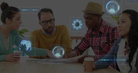 Leaning four colleagues reviewing charts in meeting room, wearing green top, showing holographic UI