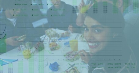 Smiling woman in blazer sitting at work table holding sandwich, drinks, charts overlay, copy space