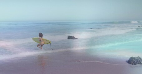 Running surfer in bikini carrying yellow shortboard into shallow surf on sandy beach, copy space