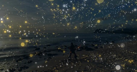 Naklejka premium Walking dark figure along sandy shore at dusk, wearing dark coat and bag amid bokeh overlay