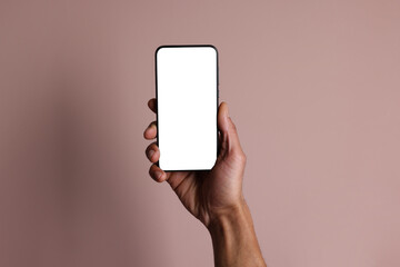Man holding smartphone with blank screen on dusty rose background, closeup. Mockup for design