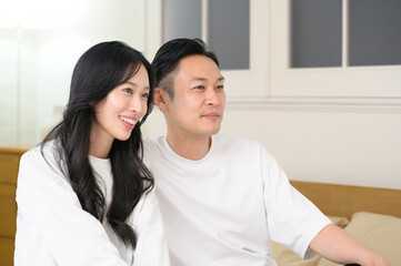 夜の寝室で笑顔で会話をする日本人男女