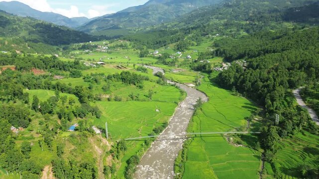 Aerial Drone View of Nuwakot Valley with River Dividing Paddy Fields and Surrounding Mountains