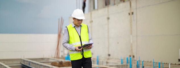 inspection, Asian Man working, Architect or contractor working on house building under construction. Professional Architects Engineer construction site. Civil Engineering in safety harthat helmet