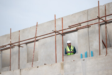 inspection, Asian Man working, Architect or contractor working on house building under construction. Professional Architects Engineer construction site. Civil Engineering in safety harthat helmet