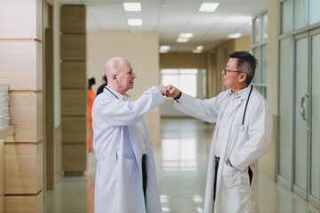 Obraz premium two doctors standing in a hospital corridor, smiling and holding each other’s hands in a celebratory gesture. highlighting unity and success in healthcare.