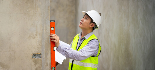 measurement horizontal deviation of construction. Balance Bubble level ruler, Tools equipment building and engineering. Civil engineer Asian man in safety hard hat helmet working at construction site