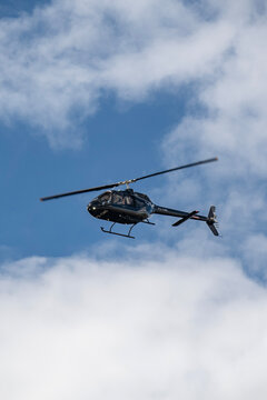 Black Eurocopter EC130 helicopter low angle flight, Private aircraft in blue sky