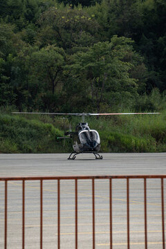 Black Eurocopter EC130 front view on ground, Luxury helicopter at helipad