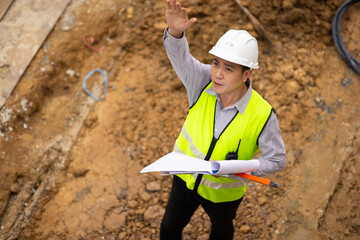 Top view above, inspection plan, Architect or contractor with blueprint working on house building under construction. Professional Architects Engineer construction site. Civil Engineering