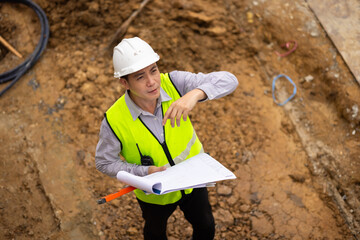 Top view above, inspection plan, Architect or contractor with blueprint working on house building under construction. Professional Architects Engineer construction site. Civil Engineering