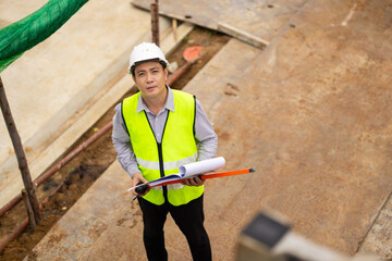 Top view above, inspection plan, Architect or contractor with blueprint working on house building under construction. Professional Architects Engineer construction site. Civil Engineering