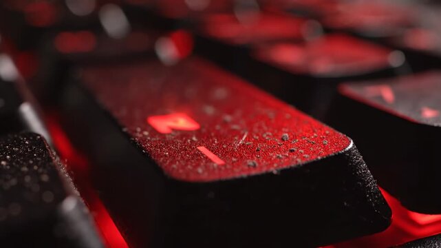 Abstract macro slow motion shot capturing the textured surface of a generic computer key illuminated by intensely flashing red light indicating a system breach keyboard, detail, glowing