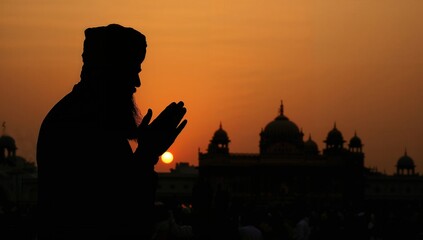 Silhouette of Man in Prayer with Golden Temple at Dusk, Sikh spirituality, peaceful worship