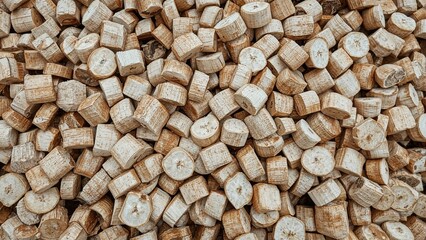 A large number of small, cylindrical wooden blocks piled together.