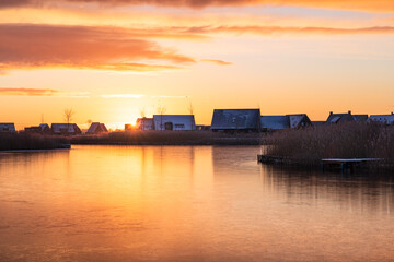 Obraz premium A colourful, winter sunrise in modern neighbourhood at the waterfront. Meerstad, the Netherlands.