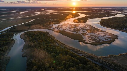 Aerial view of rivers and wetlands at sunset with reflection of the sky. Nature landscape, waterways, and ecological areas. The scene of water, forest, and sunset at dusk.