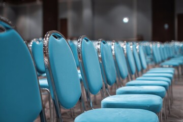 Modern Conference Room with Rows of Empty Blue Chairs in Neat Arrangement.