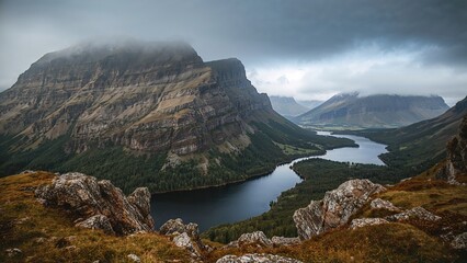 Mountain landscape with a river and rocky foreground under cloudy sky. Natural scenery and wilderness.