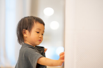 Curious Toddler Touching Air Purifier Indoors.
