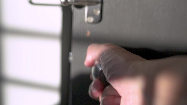 Hand Closing Door by Turning Doorknob in Home Interior
