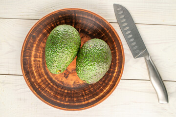 Ripe avocados on a wooden table, close-up, top view.