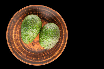 Ripe avocado isolated on black background, close-up, top view.