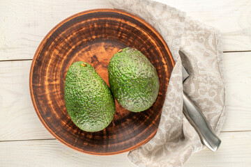 Ripe avocados on a wooden table, close-up, top view.
