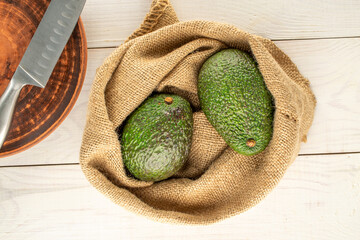 Ripe avocados on a wooden table, close-up, top view.