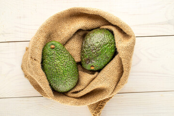 Ripe avocados on a wooden table, close-up, top view.
