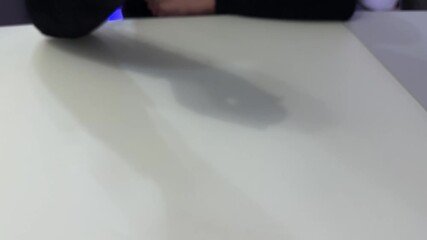 A girl's hand throws a boiled egg in its shell onto the table - Powered by Adobe