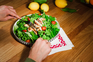 woman eating chicken salad with green lettuce, grilled chicken meat, green peas, lemons, fresh natural healthy mediterranean meal