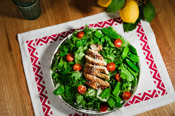 healthy chicken salad with lettuce, green peas, cherry tomatoes, olive oil dressing, flat lay
