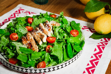 healthy chicken salad with lettuce, green peas, cherry tomatoes, olive oil dressing, close up